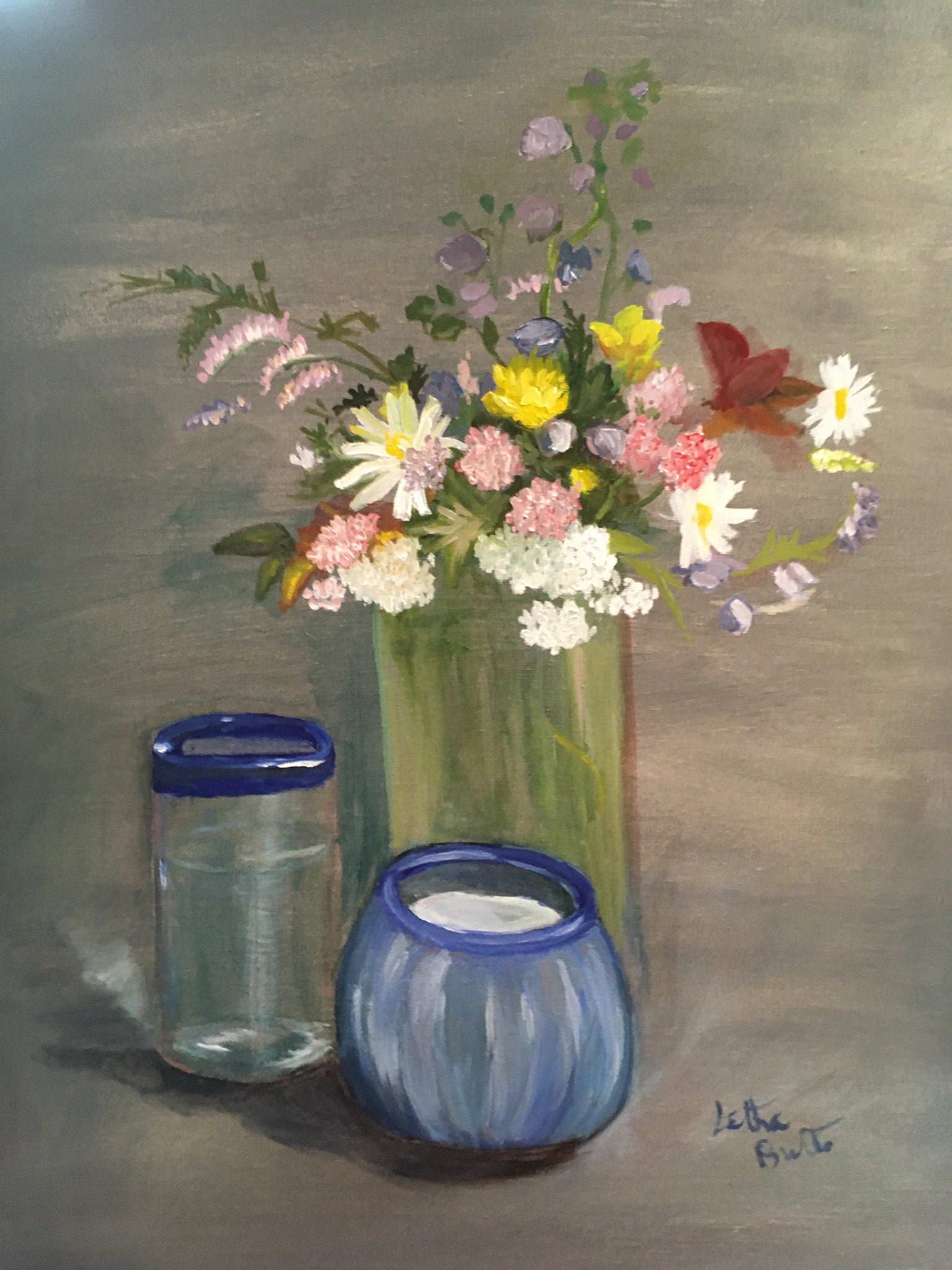 A still life, with a candle in a blue holder, a glass with a blue rim, and a vase full of flowers. 